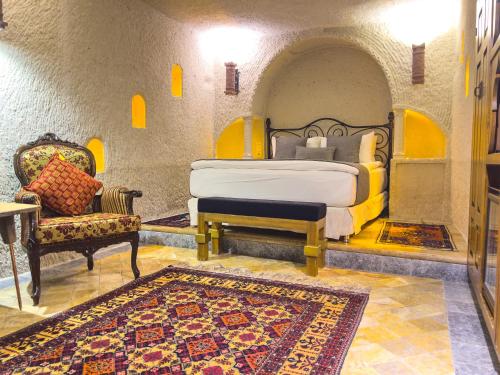 格雷梅本地岩洞酒店的一间卧室配有一张床、一把椅子和地毯