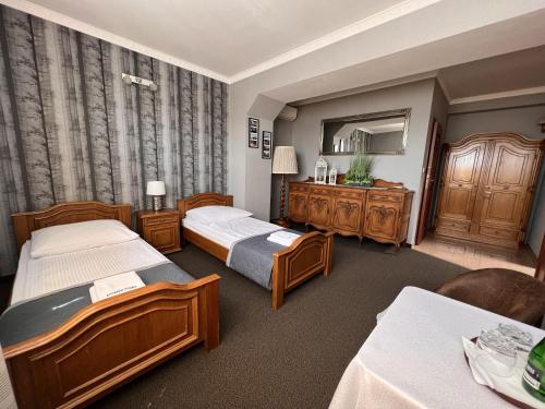 MogilnoNoclegi-Restauracja Boss的酒店客房,设有两张床和镜子