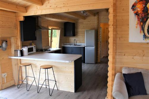 伊夫舍姆Stunning 5-Bed Cabin in Ashton Under Hill的小木屋内的厨房,配有柜台和凳子