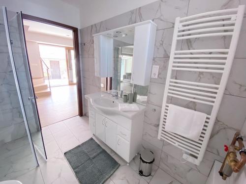 蒂豪尼Piros Vendégház的白色的浴室设有水槽和镜子