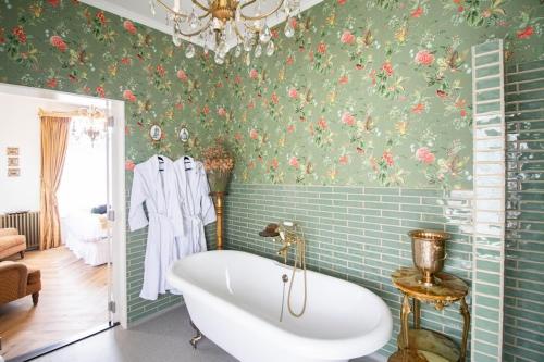 德斯泰赫Hotellerie Het Wapen Van Athlone的带浴缸的浴室和花卉壁纸