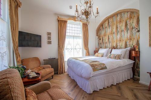 德斯泰赫Hotellerie Het Wapen Van Athlone的一间卧室配有一张大床和一张沙发