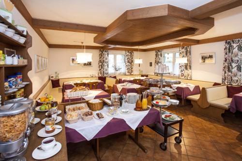 萨尔察赫河畔戈灵卡斯豪司松克勒酒店的一间餐厅配有桌椅,提供食物