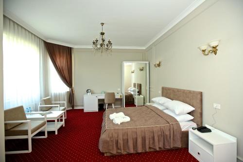 巴库Miraj hotel的一间卧室配有一张床、一张桌子和一把椅子