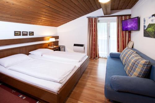 萨尔察赫河畔戈灵卡斯豪司松克勒酒店的一间卧室配有一张大床和一张蓝色的沙发