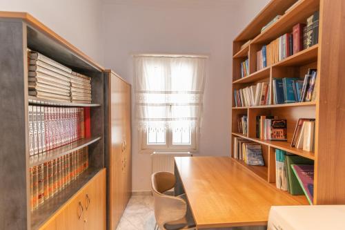 纳克索乔拉Evangelia's Mansion的一间设有木桌和书架的房间