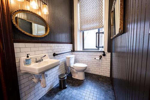 匹兹堡Traveler's Rest Hotel的一间带水槽、卫生间和镜子的浴室