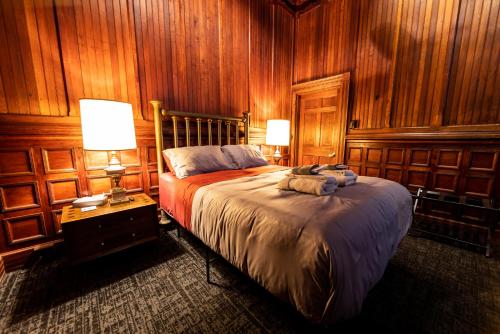 匹兹堡Traveler's Rest Hotel的一间卧室设有木墙和一张带两盏灯的床。