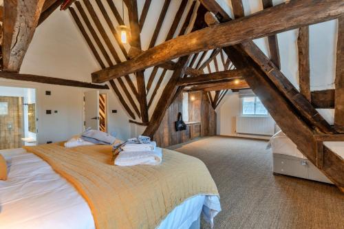 佩恩斯威克Finest Retreats - The Half-ARC of Painswick的一间卧室设有一张带木梁的大床