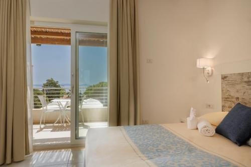 圣安蒂奥科Mercury Beach Hotel的一间卧室设有一张床,享有阳台的景色