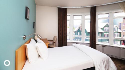 雷克雅未克Center Hotels Klopp的一间卧室设有一张大床和一个窗户。
