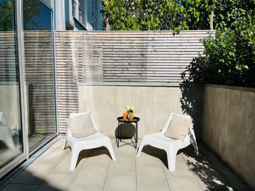 莱昂贝格FeWo Silberberg im Loftstil mit Terrasse的庭院里设有两把白色的椅子和一张桌子