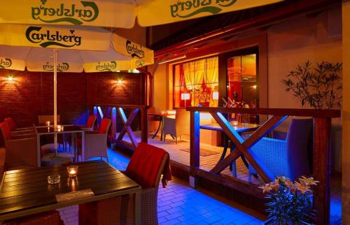 绿山城Aura - Hotel & Restaurant & Sauna的一间带桌椅和阳台的餐厅
