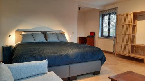 Sint-Pieters-LeeuwThe Kettle House - Manor的一间卧室配有一张大床和一张沙发