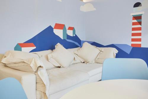 努马纳Villa Ulisse - Suites - Luxury B&B的墙上壁画的白色沙发
