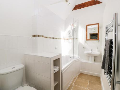 NymphsfieldTump Cottage的白色的浴室设有卫生间和水槽。