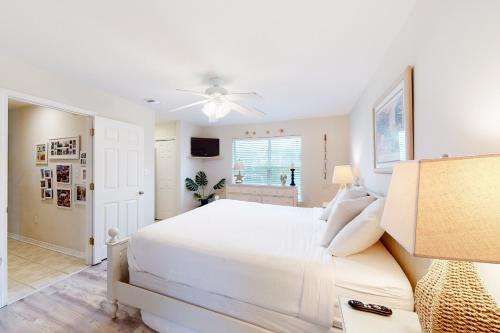 德斯坦Sea Breeze Cottage的卧室配有白色的床和吊扇