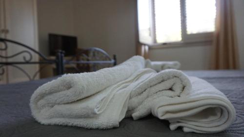 锡拉库扎Country house relais Nonna Rosa Rosolini (SR)的床上的一堆白色毛巾