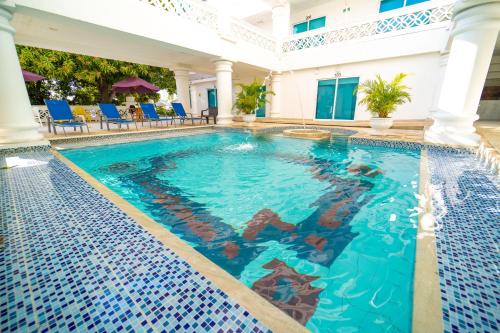圣玛尔塔Hotel Santorini Casablanca的一座带蓝色椅子的酒店游泳池