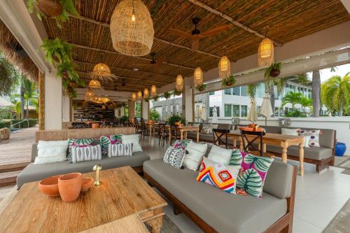 拉威海滩Selina Serenity Rawai Phuket的带沙发和桌椅的天井。