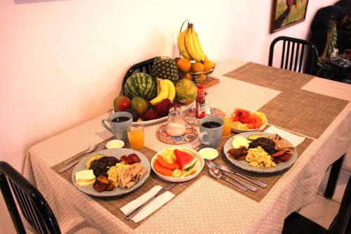 圣何塞F&M Guesthouse的一张桌子,上面放着食物和水果盘