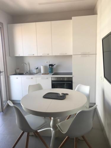 雷卡纳蒂港SeSil Amare的白色的厨房配有白色的桌子和椅子
