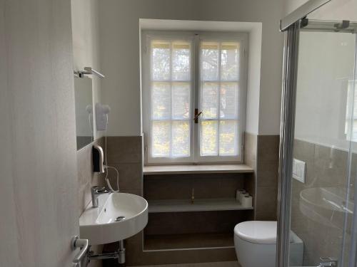 斯特雷萨Villa Vittoria的一间带水槽和卫生间的浴室以及窗户。