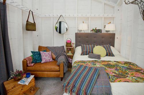 史宾桥Laggan Bothies的一间卧室配有一张床、一张沙发和一把椅子
