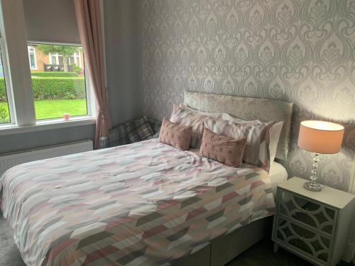 巴洛赫Nairoo的一间卧室配有一张带五颜六色的被子的床和窗户