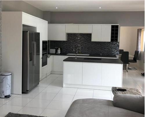 格罗斯岛Belle Luxury Apartments的厨房配有白色橱柜和黑色台面