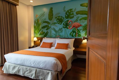 碧瑶Giraffe Boutique Hotel的卧室配有一张大床,墙上挂有绘画作品