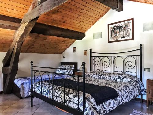 PremenoLa Stazione的一间设有黑色床的卧室,位于一个拥有木制天花板的房间