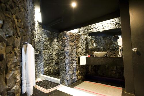 Manase史蒂文森马纳塞酒店的带石墙、水槽和毛巾的浴室