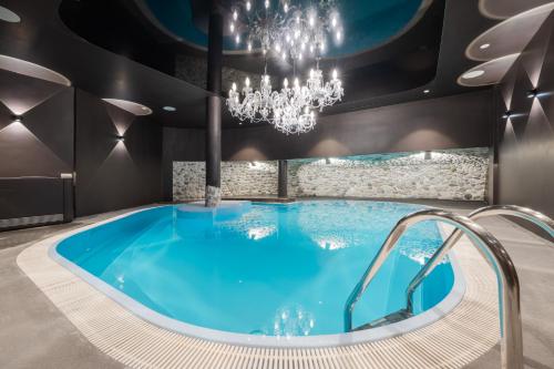 洛伊塔施Hotel Kristall - Adults only的配有吊灯的客房内的热水浴池
