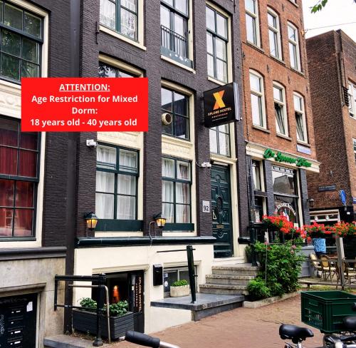 阿姆斯特丹Xplore Hostel Amsterdam的带有指示牌的建筑物,可读取注意年龄,用于有线