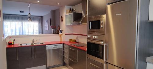 特伦普Ca l'Esmolet的厨房配有不锈钢用具和红色台面