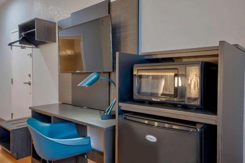 丹尼森Motel 6-Denison, TX的厨房配有微波炉和蓝椅