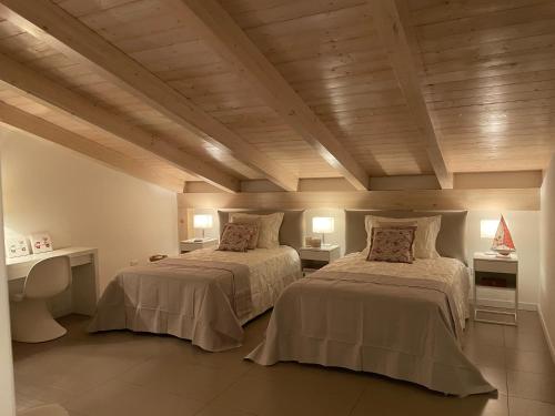 罗萨诺Villa Fiorentino的配有木天花板的客房设有两张床。