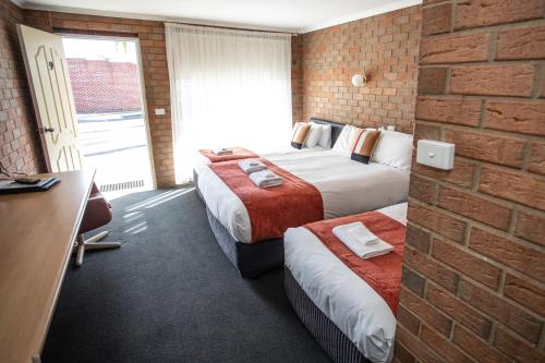 莫阿马莫亚马汽车旅馆的酒店客房带两张床和砖墙