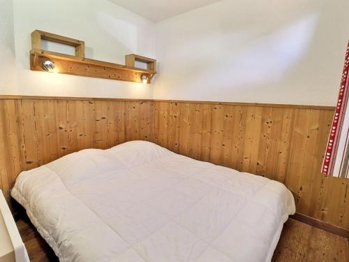 谷雪维尔Appartement La Tania, 2 pièces, 4 personnes - FR-1-182A-21的一间带木镶板的卧室和一张床铺