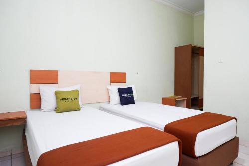 ParepareUrbanview Hotel Platinum Parepare的配有两张床的酒店客房中的两张床