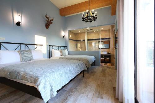 Shunan后山城宝民宿的卧室设有两张床铺和蓝色的墙壁
