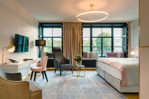 克拉科夫Hotel Ferreus Modern Art Deco的酒店客房,配有一张床、一张桌子和椅子