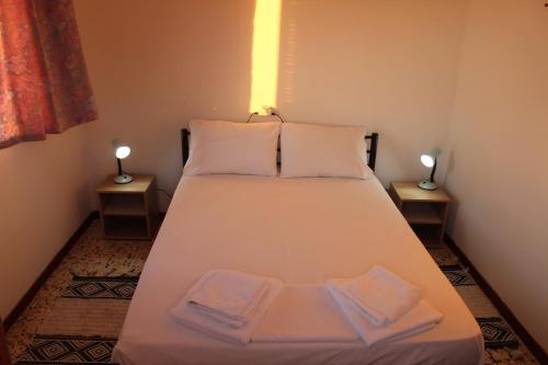 罗达Anastazia's Seaside Apartments的一张位于带两盏灯的小房间的床
