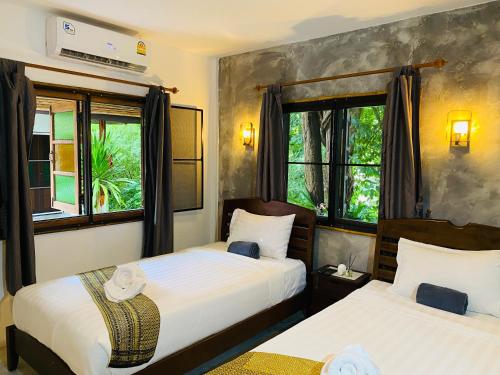 奥南海滩Pagi Pagi villas的带2扇窗户的客房内的2张床