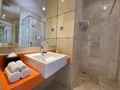马卡萨Swiss-Belcourt Makassar的浴室配有白色水槽和淋浴。