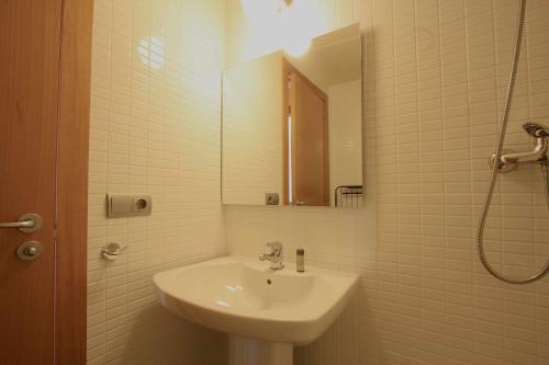 马塔罗Mazi Apartments Downtown的白色的浴室设有水槽和镜子