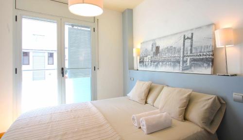 马塔罗Mazi Apartments Downtown的卧室配有一张白色床,墙上挂着一幅画