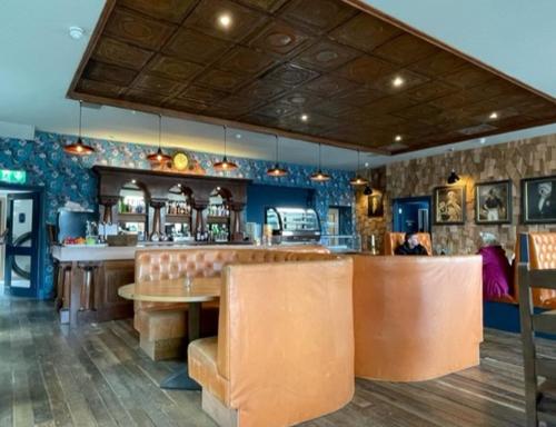巴洛赫Loch Lomond Hotel的餐厅设有酒吧,配有桌椅