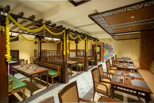 库姆巴科纳姆维哈品质酒店的用餐室配有木桌和椅子